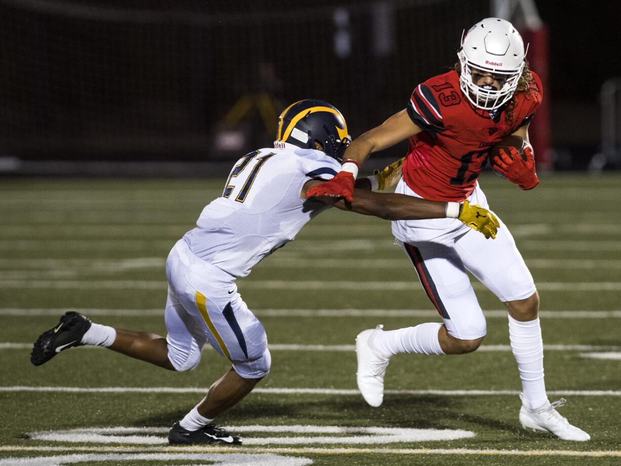 Bellevue's Javon Griggs (21) tries to take down Camas' Luc Sturbelle (13) during Friday night's game at Doc Harris Stadium in Camas on Sept. 21, 2018.