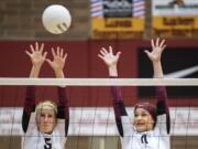 Prairie's Jamie Packer (5) and Amelia Renner (11) jump to block a spike during Tuesday night's game against Kelso at Prairie High School in Camas on Sept. 25, 2018.