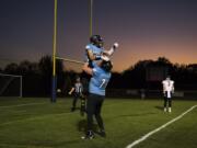 Hockinson's Peyton Brammer (9) celebrates a 26-yard touch down with teammate Nathan Balderas (71) during Friday night's game in Hockinson on Sept. 28, 2018.