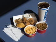 A honey biscuit, clockwise from left, blueberry biscuit, Cajun chicken tenders with ranch, soda, jambalaya and mac and cheese are pictured at Krispy Krunchy Chicken in Battle Ground.