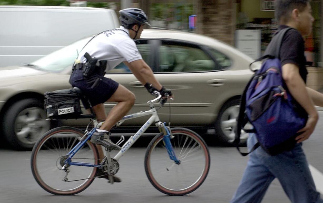 Vancouver police Officer Ed Letarte patrols Sixth Street in downtown Vancouver in July 2002. The police department is re-implementing the bike officer unit for the first time in nearly a decade.