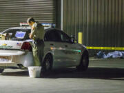 A Kern County sheriff's deputy stands near an area where a shooting victim lies, Wednesday, Sept. 12, 2018, in Bakersfield, Calif. A gunman killed five people, including his wife, before turning the gun on himself, authorities said.