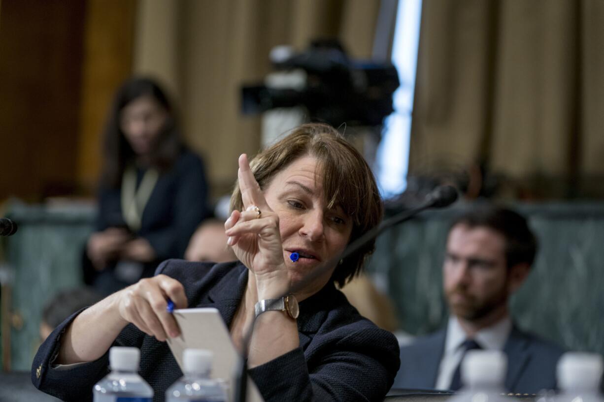 Sen. Amy Klobuchar, D-Minn., holds up her hand to speak as she shares a note with a colleague during a Senate Judiciary Committee markup meeting on Capitol Hill, Thursday, Sept. 13, 2018, in Washington. The committee will vote next week on whether to recommend President Donald Trump's Supreme Court nominee, Brett Kavanaugh for confirmation. Republicans hope to confirm him to the court by Oct.