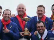 Europe team captain Thomas Bjorn, center, holds the trophy as he celebrates with his team after Europe won the Ryder Cup on the final day of the 42nd Ryder Cup at Le Golf National in Saint-Quentin-en-Yvelines, outside Paris, France, Sunday, Sept. 30, 2018.