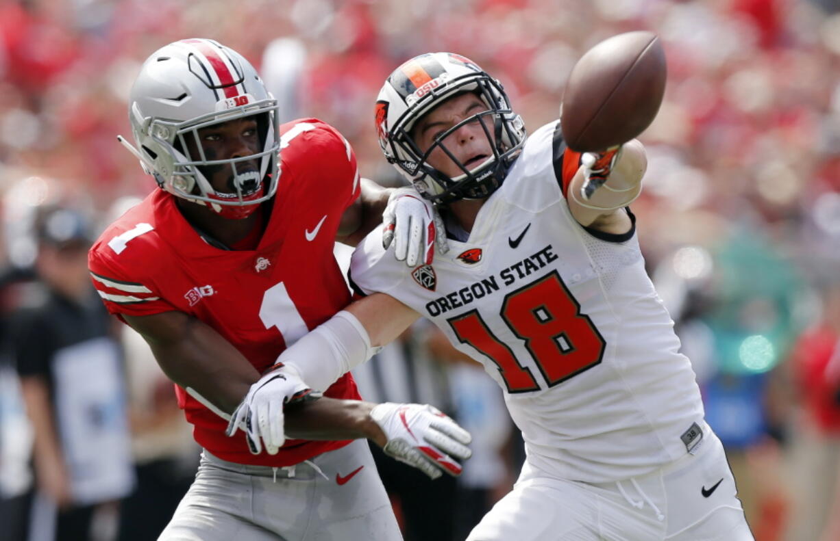 Ohio State defensive back Jeffrey Okudah, left, knocks the ball away from Oregon State wide receiver Timmy Hernandez during the first half of an NCAA college football game Saturday, Sept. 1, 2018, in Columbus, Ohio.