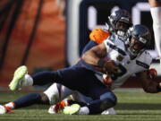 Denver Broncos linebacker Von Miller, behind, hauls down Seattle Seahawks quarterback Russell Wilson (3) for a sack during the second half of an NFL football game Sunday, Sept. 9, 2018, in Denver.