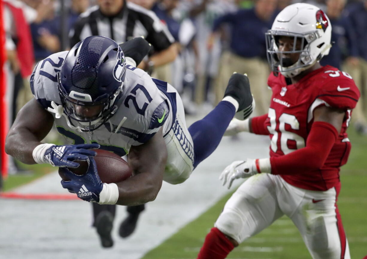 Seattle Seahawks running back Mike Davis (27) dives in for a touchdown as Arizona Cardinals defensive back Budda Baker (36) defends during the first half of an NFL football game, Sunday, Sept. 30, 2018, in Glendale, Ariz.