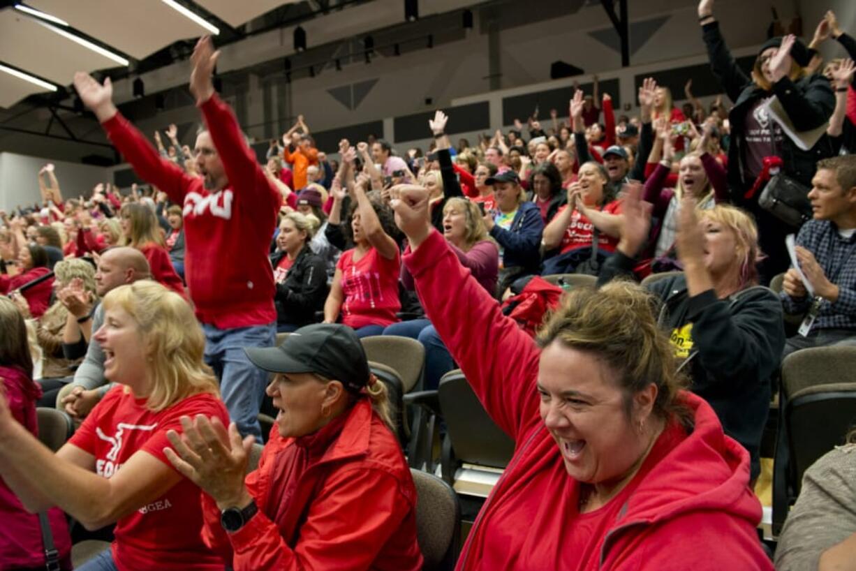 Yacolt Primary School teacher Stacy Reese of Ariel, lower right, reacts Sunday to the tally of the Battle Ground teacher’s union vote at Battle Ground High School. The union ratified a contract and classes will start today in the district.