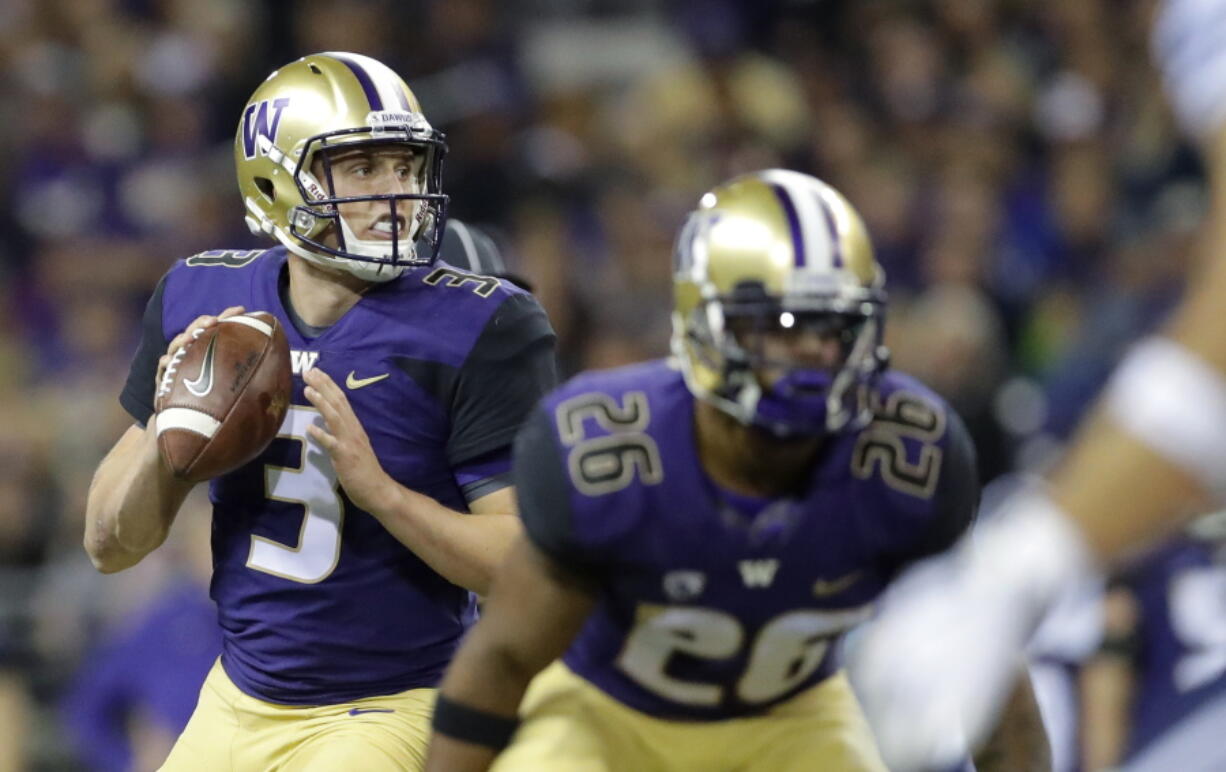 Washington quarterback Jake Browning looks to pass behind running back Salvon Ahmed during the second half of an NCAA college football game against BYU, Saturday, Sept. 29, 2018, in Seattle. (AP Photo/Ted S.