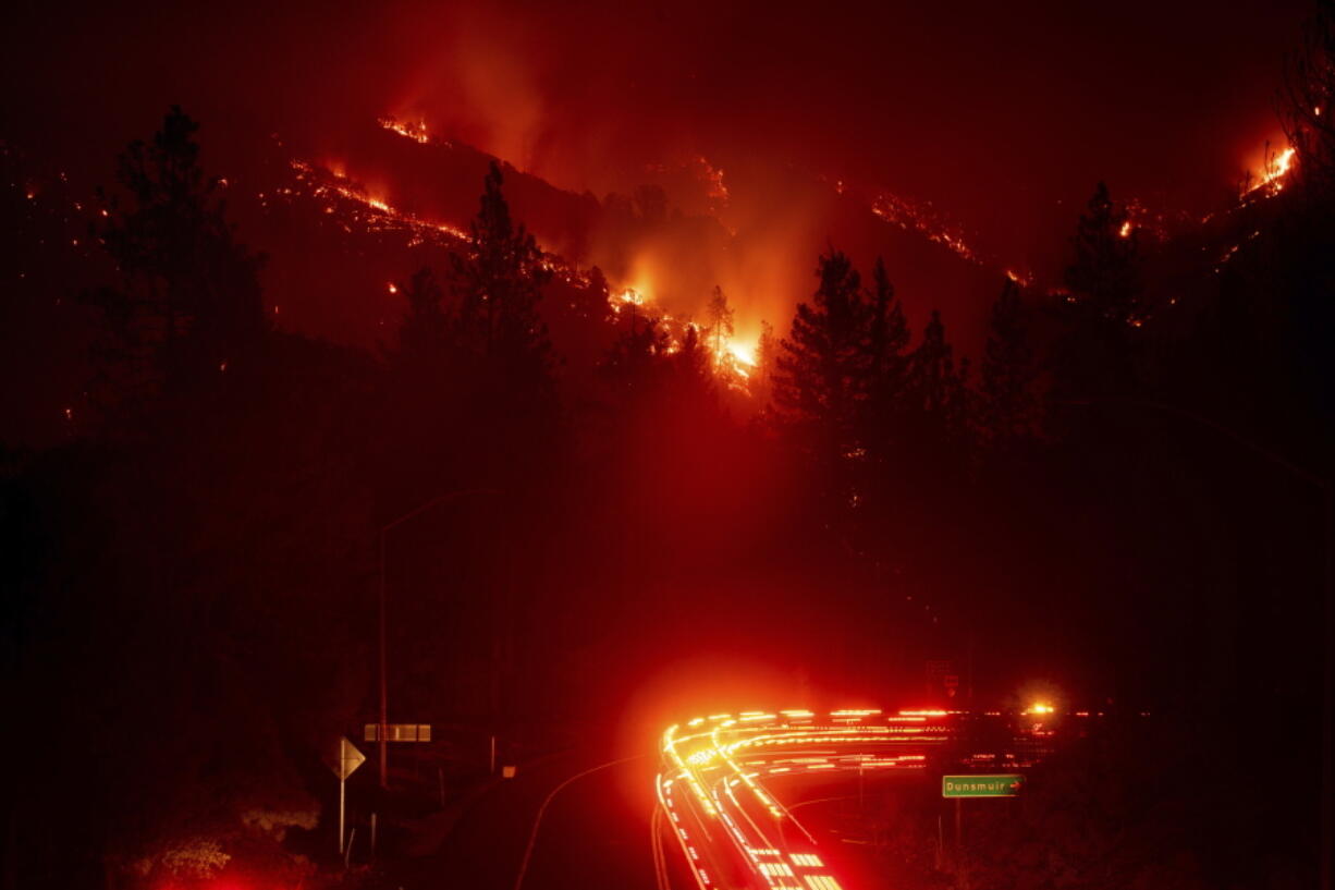 Fire trucks pass the Delta Fire burning in the Shasta-Trinity National Forest, Calif., on Wednesday, Sept. 5, 2018. Parked trucks lined more than two miles of Interstate 5 as both directions remained closed to traffic.