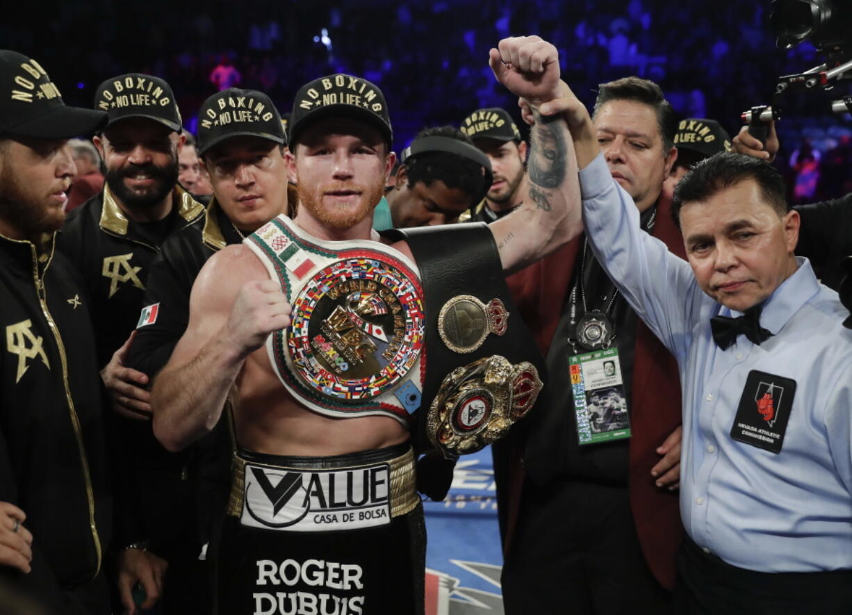 Canelo Alvarez poses for a photo with referee Benjy Esteves Jr., right, after defeating Gennady Golovkin by majority decision in a middleweight title boxing match, Saturday, Sept. 15, 2018, in Las Vegas.