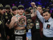 Canelo Alvarez poses for a photo with referee Benjy Esteves Jr., right, after defeating Gennady Golovkin by majority decision in a middleweight title boxing match, Saturday, Sept. 15, 2018, in Las Vegas.