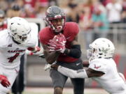 Eastern Washington defensive back Mitch Fettig (4) and defensive back Josh Lewis, right, tackle Washington State wide receiver Davontavean Martin during the first half of an NCAA college football game in Pullman, Wash., Saturday, Sept. 15, 2018.