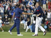 Europe’s Francesco Molinari, left, shakes hands with Jordan Spieth of the US after winning a foursome match with his partner Tommy Fleetwood on the opening day of the 42nd Ryder Cup at Le Golf National in Saint-Quentin-en-Yvelines, outside Paris, France, Friday, Sept. 28, 2018. Molinari and Fleetwood beat Justin Thomas of the US and Jordan Spieth 5 and 4.