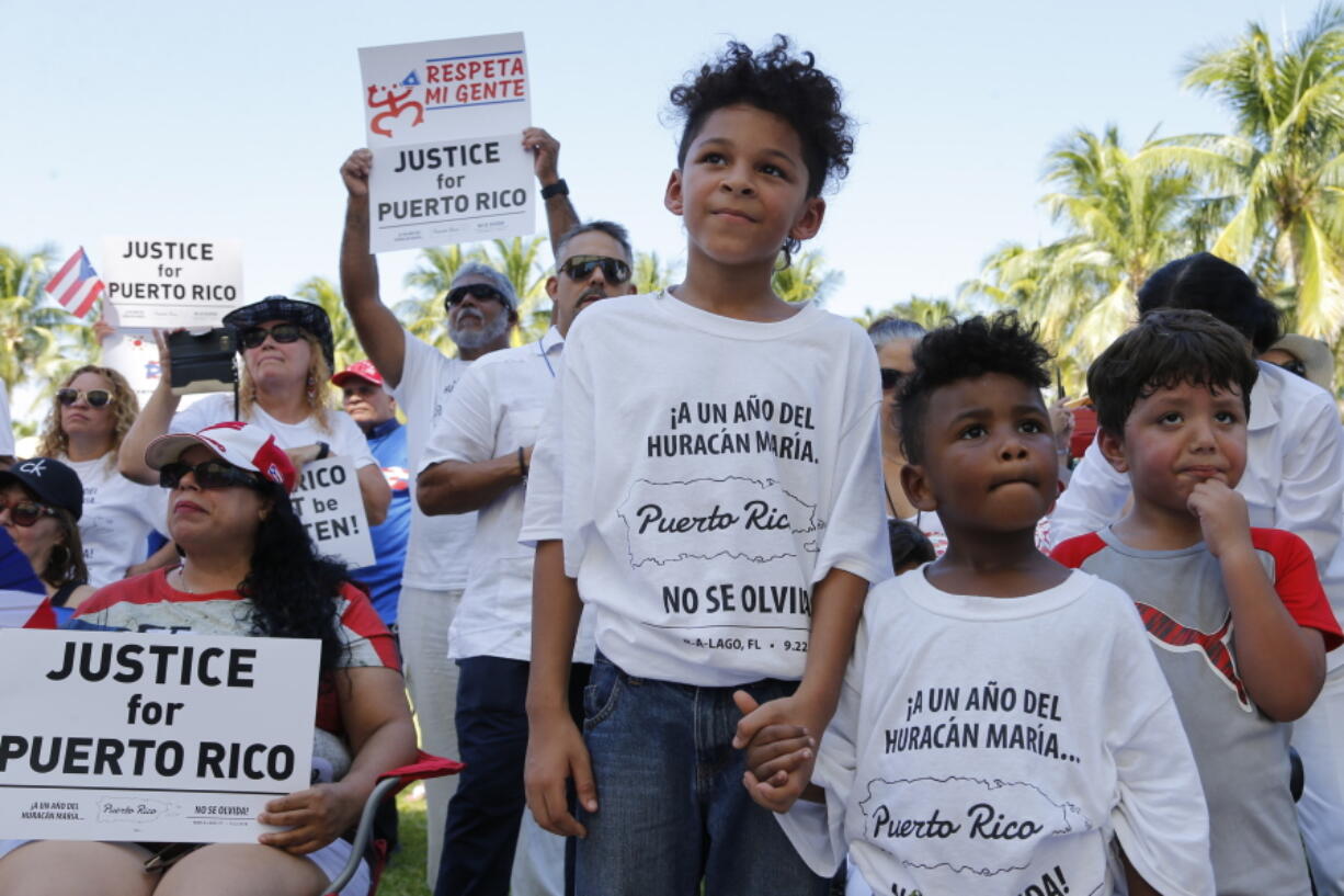 Hector Rivera, 8, Mario Jordan Micael, 3, and Ramon Montes, 5, participate in a rally Saturday in West Palm Beach, Fla., marking the one-year anniversary of Hurricane Maria’s devastation of Puerto Rico.