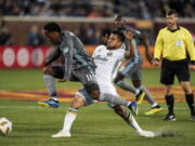 Minnesota United midfielder Romario Ibarra leaps into air while chasing the ball under the defense of Portland Timbers midfielder Andres Flores (14) during the first half of an MLS soccer match Saturday, Sept. 22, 2018, in Minneapolis.