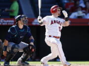 Los Angeles Angels’ Kole Calhoun, right, hits a solo home run with Seattle Mariners catcher Mike Zunino watching during the seventh inning of a baseball game in Anaheim, Calif., Sunday, Sept. 16, 2018.