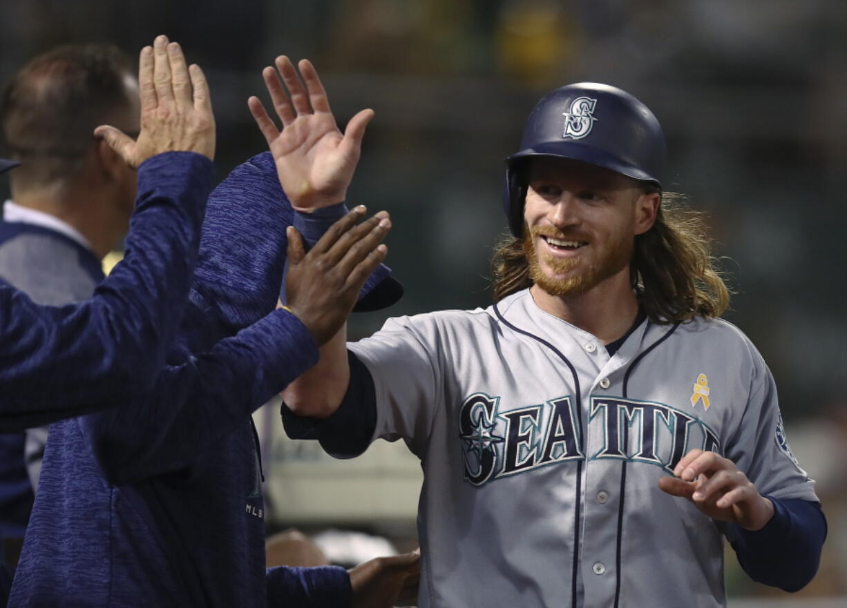 Seattle Mariners’ Ben Gamel is congratulated after scoring against the Oakland Athletics during the fifth inning of a baseball game Saturday, Sept. 1, 2018, in Oakland, Calif.