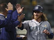 Seattle Mariners’ Ben Gamel is congratulated after scoring against the Oakland Athletics during the fifth inning of a baseball game Saturday, Sept. 1, 2018, in Oakland, Calif.