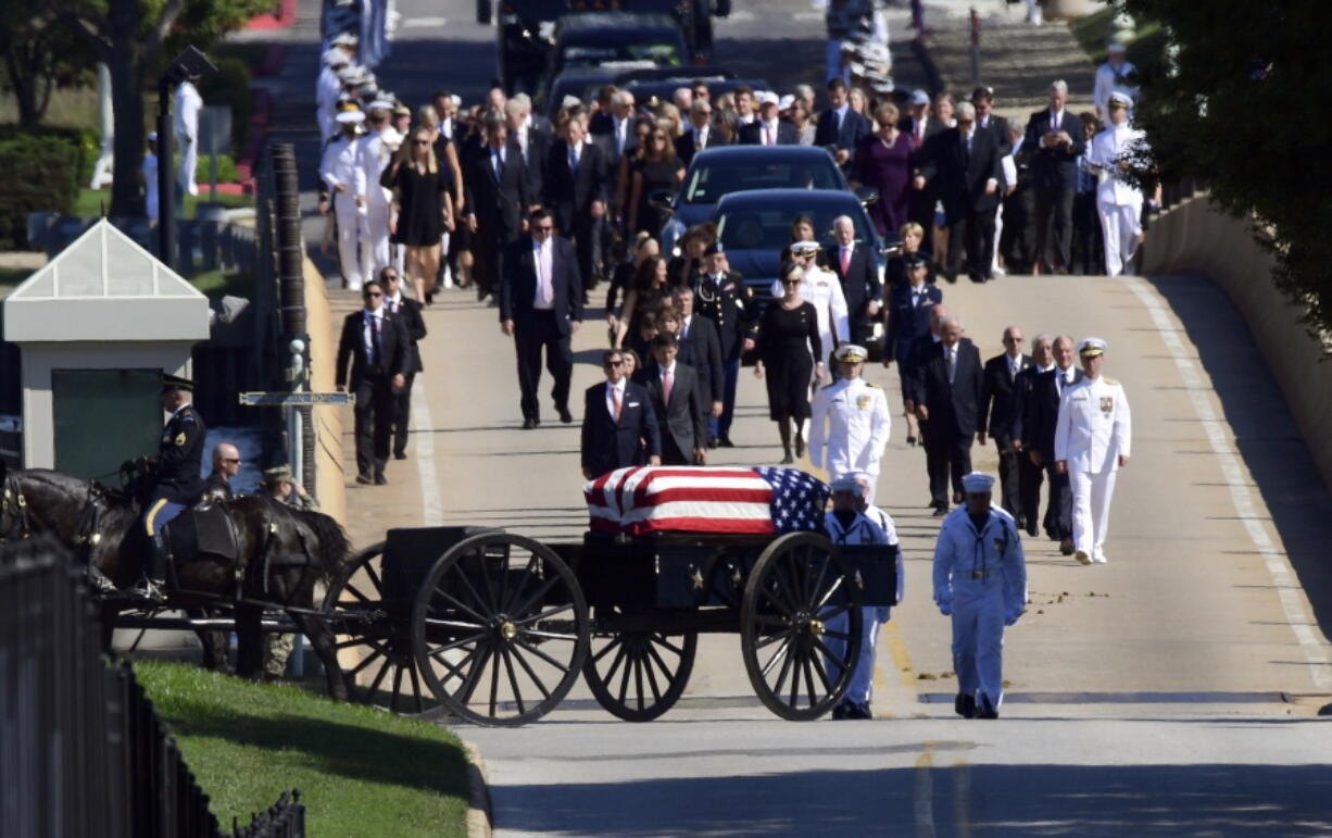 Family members, including Cindy McCain, back center, follow a horse-drawn caisson that carries the casket of Sen. John McCain, R-Ariz., as it proceeds to the United States Naval Academy cemetery in Annapolis, Md., Sunday, for burial. McCain died Aug. 25 from brain cancer at age 81.