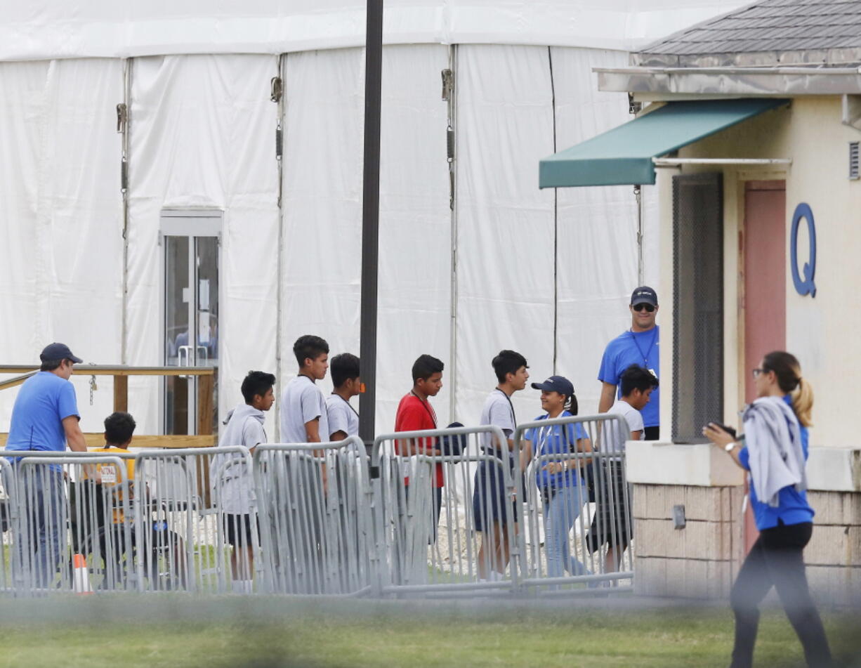 Immigrant children walk in a line outside the Homestead Temporary Shelter for Unaccompanied Children on June 20 in Homestead, Fla.