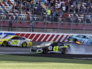 Ryan Blaney (12) drives past the wrecked cars of Jimmie Johnson (48) and Martin Truex Jr. (78) to win the NASCAR Cup series auto race at Charlotte Motor Speedway in Concord, N.C., Sunday, Sept. 30, 2018.