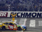 Kyle Busch (18) celebrates winning the NASCAR Cup Series auto race at Richmond Raceway in Richmond, Va., Saturday, Sept. 22, 2018.