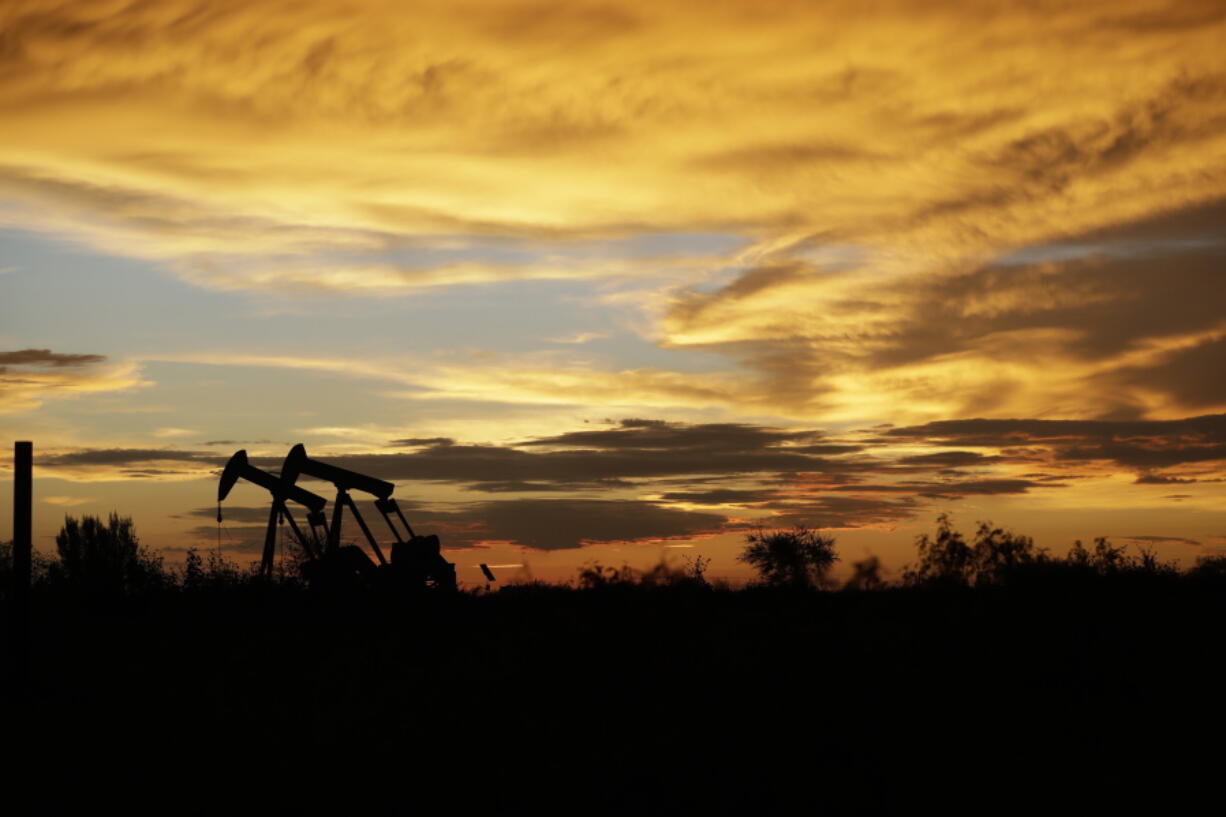 FILE- In this June 5, 2017, file photo pumpjacks work in an oil field at sunset after a thunderstorm passed through the area in Karnes City, Texas. The United States may have reclaimed the title of the world’s biggest oil producer sooner than expected. The U.S. Energy Information Administration said Wednesday that America “likely surpassed” Russia in June and August after jumping over Saudi Arabia earlier this year.