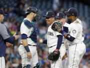 Seattle Mariners starting pitcher Erasmo Ramirez, center, smiles while being relieved against the Baltimore Orioles in the sixth inning of a baseball game Monday, Sept. 3, 2018, in Seattle.