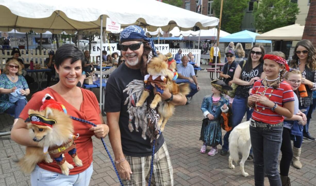 Meshelle Sharples, left, and Raynel Hunt carry Romeo and Raja to collect their parade prize Saturday during Pirates in the Plaza in Washougal.