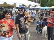 Meshelle Sharples, left, and Raynel Hunt carry Romeo and Raja to collect their parade prize Saturday during Pirates in the Plaza in Washougal.