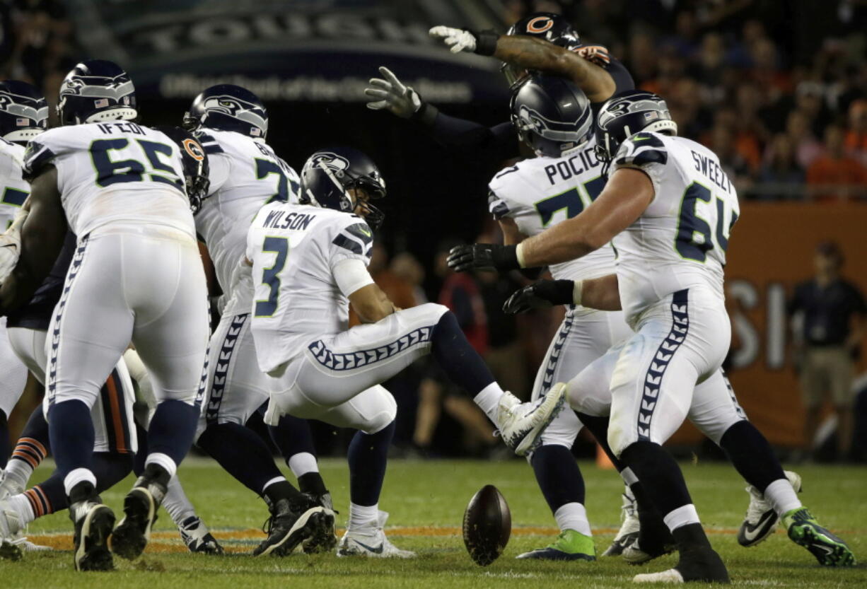 Seattle Seahawks quarterback Russell Wilson (3) loses a ball during the first half of an NFL football game against the Chicago Bears Monday, Sept. 17, 2018, in Chicago.