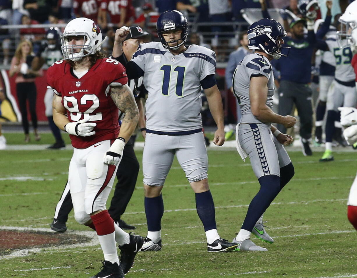 Seattle Seahawks kicker Sebastian Janikowski (11) celebrate his game-winning field goal with punter Michael Dickson (4) as Arizona Cardinals linebacker Dennis Gardeck (92) looks away during the second half of an NFL football game, Sunday, Sept. 30, 2018, in Glendale, Ariz. The Seahawks won 20-17. (AP Photo/Ross D.