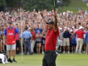 Tiger Woods celebrates after picking up his putt for par on the 18th green to win the final round of the Tour Championship golf tournament Sunday, Sept. 23, 2018, in Atlanta.