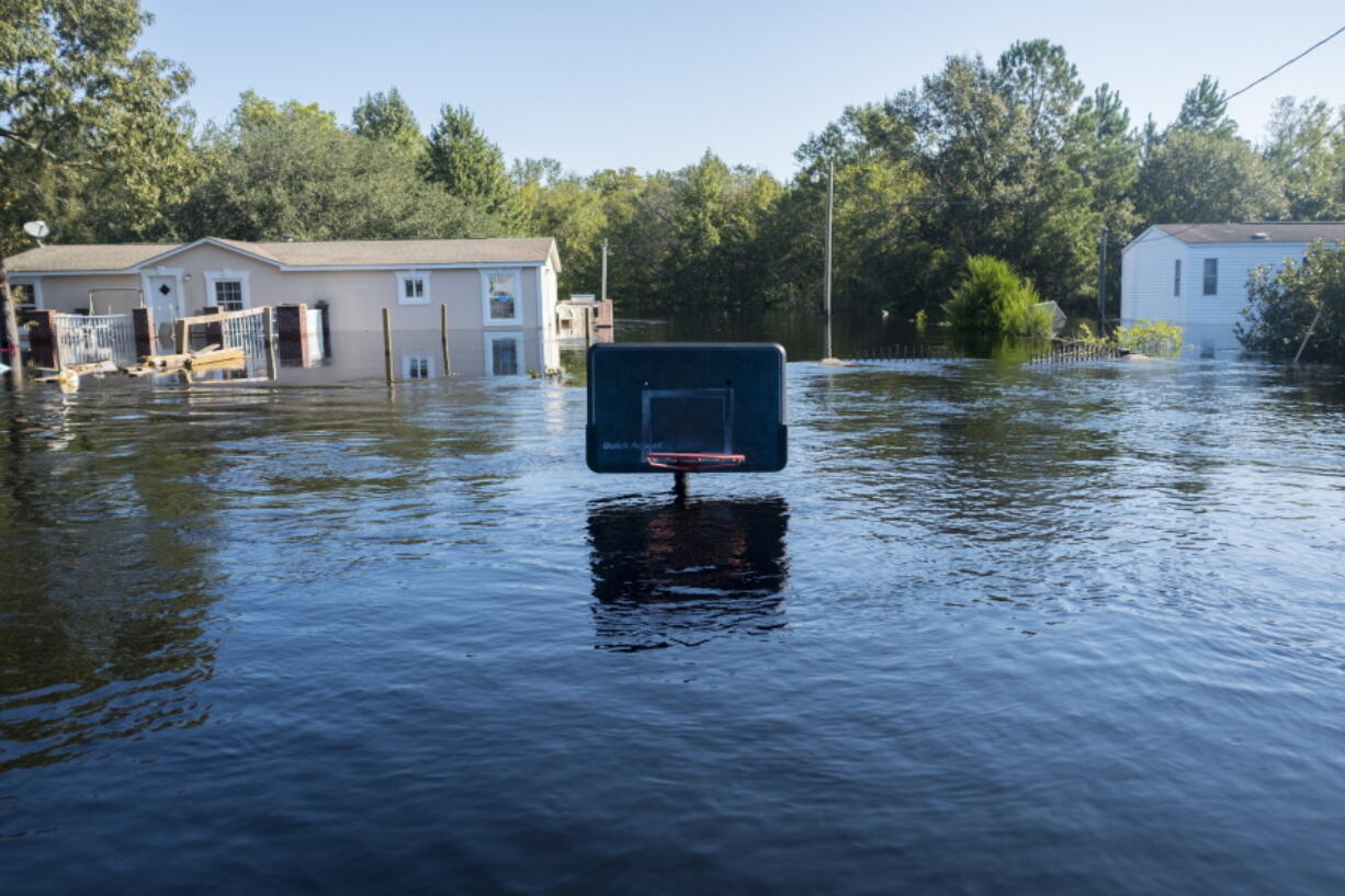 A basketball net barely sticks up above the flood waters at Lee’s Landing in Conway, S.C., on Wednesday. Predictions for the final communities in the path of Hurricane Florence’s flooding aren’t as dire as they once were. Officials originally expected flooding in the worst areas of Georgetown County to be from 5 to 10 feet. But the latest forecast lowered that estimate and the Waccamaw River in Conway has been at the same level for nearly a day.