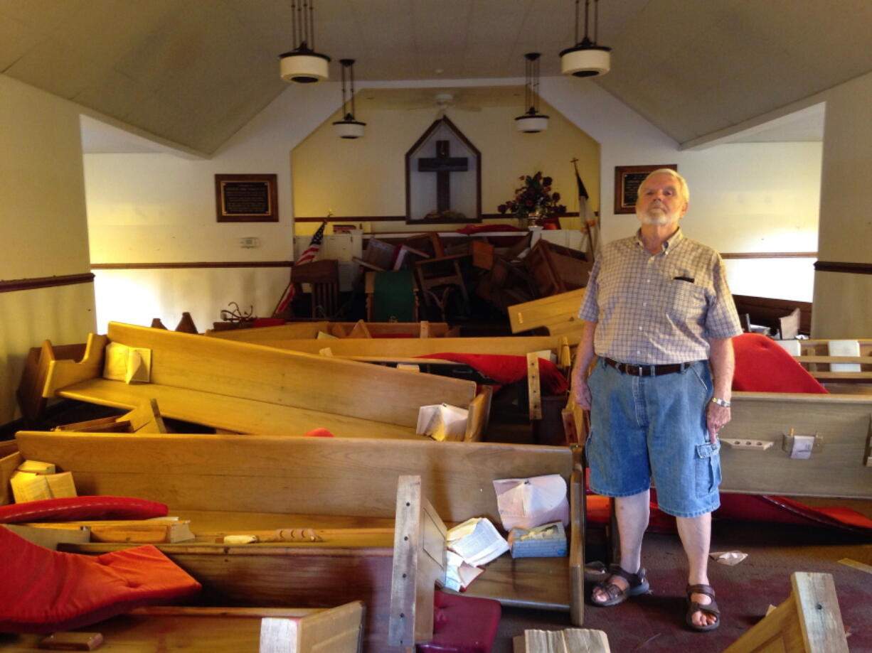 Pastor Floyd Benfield stands in front of the flood-damaged sanctuary of the Presbyterian Church of the Covenant in Spring Lake, N.C., Thursday, Sept. 20, 2018. Just days before, the flooding Little River had left the church half submerged.