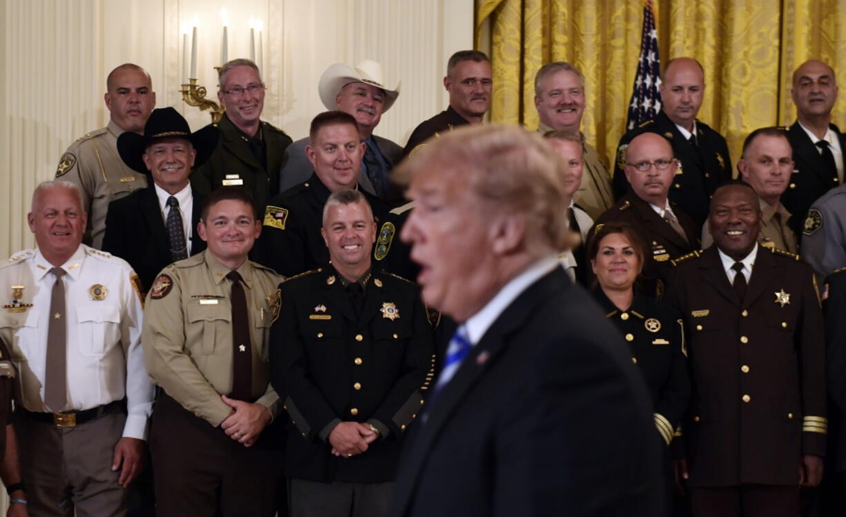 Sheriffs listens as President Donald Trump responds to a reporters question during an event in the East Room of the White House in Washington, Wednesday, Sept. 5, 2018.