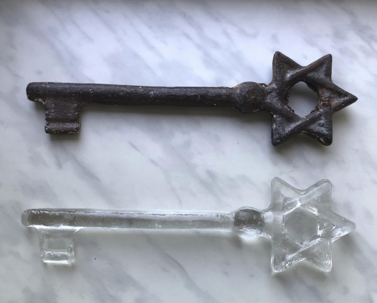 In this undated photo provided by artist Rachel Stevens an old synagogue key discovered by Stevens at a market in Lviv, Ukraine, and a glass replica that she made modeled on it are photographed. Seventy-five of the glass replicas were presented to people working to preserve the memory of the Jews of Lviv and the region during a ceremony marking the 75th anniversary of the destruction of the city’s Jewish community in the Holocaust on Sunday.