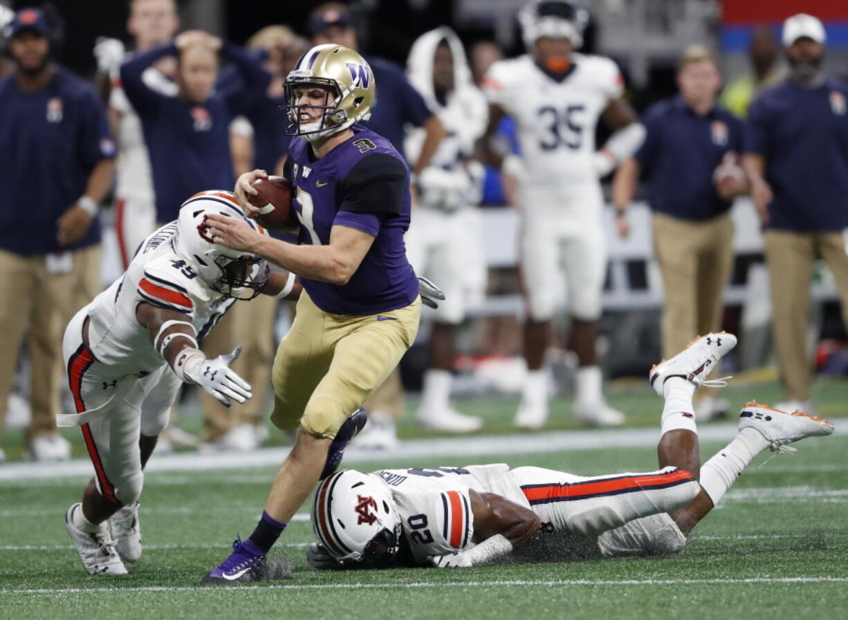 Washington quarterback Jake Browning (3) is stopped by Auburn's Darrell Williams (49) and Jeremiah Dinson (20) after running for a first down during the second half of an NCAA college football game Saturday, Sept. 1, 2018, in Atlanta. Auburn won 21-16.