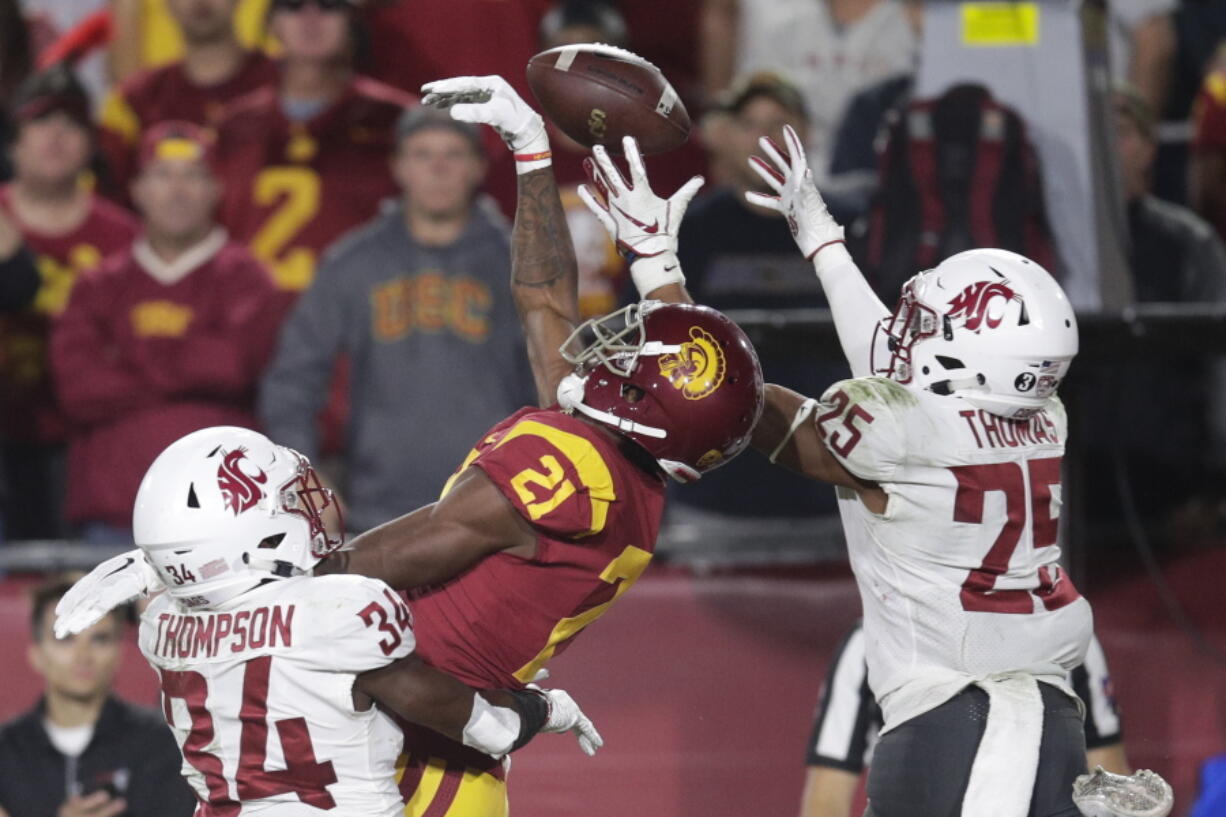 Southern California wide receiver Tyler Vaughns, center, misses a pass between Washington State safety Jalen Thompson, left, and safety Skyler Thomas during the first half of an NCAA college football game Friday, Sept. 21, 2018, in Los Angeles. (AP Photo/Jae C.