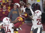 Southern California wide receiver Tyler Vaughns, center, misses a pass between Washington State safety Jalen Thompson, left, and safety Skyler Thomas during the first half of an NCAA college football game Friday, Sept. 21, 2018, in Los Angeles. (AP Photo/Jae C.