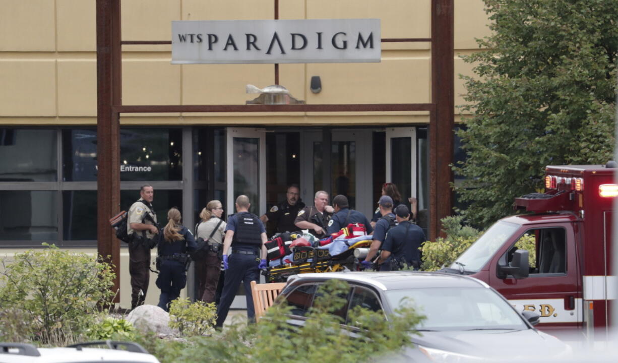 Emergency personnel arrive on the scene of a shooting at a software company in Middleton, Wis., Wednesday. Four people were shot and wounded during the shooting in the suburb of Madison, according to a city administrator.