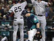 New York Yankees’ Gleyber Torres, left, jumps to celebrate with Luke Voit, right, above Seattle Mariners catcher Mike Zunino after Torres hit a two-run home run to score Voit during the second inning of a baseball game Friday, Sept. 7, 2018, in Seattle. (AP Photo/Ted S.