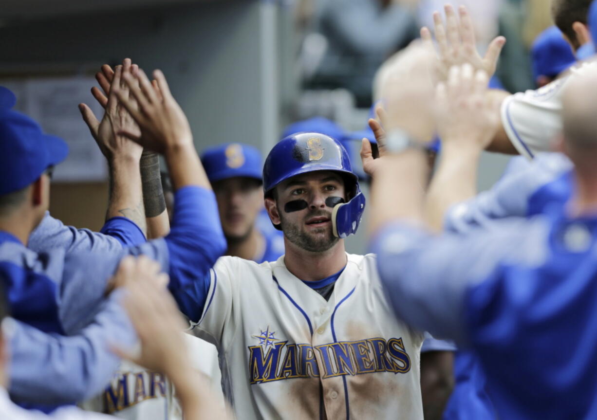 Seattle Mariners’ Mitch Haniger is congratulated in the dugout after scoring against the New York Yankees during the eighth inning of a baseball game, Sunday, Sept. 9, 2018, in Seattle.