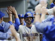 Seattle Mariners’ Mitch Haniger is congratulated in the dugout after scoring against the New York Yankees during the eighth inning of a baseball game, Sunday, Sept. 9, 2018, in Seattle.