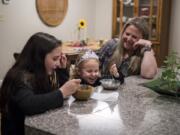 Lacey Wescom, 12, from left, her sister Tillie Thornber, 3, and their mother Wendi Thornber eat ice cream together on Sept. 19 at their home in Hazel Dell. The family used to be homeless, but has made significant strides. This summer Wendi Thornber graduated from Clark College and began a full-time job with PeaceHealth.