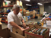 Northeast Hazel Dell: John Cameron organizing books for school shopping day at Share as part of D.A. Davidson Day.