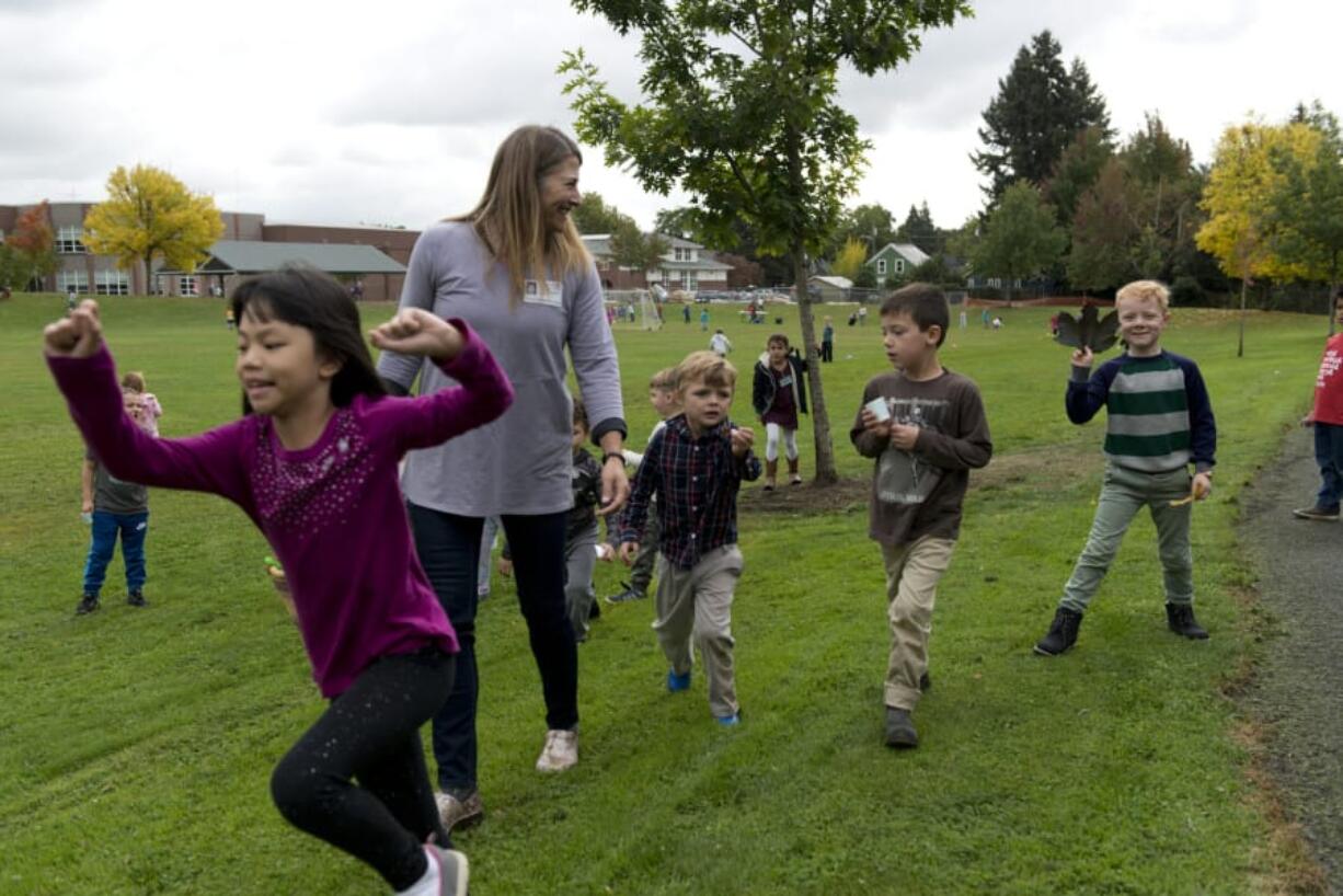 Cheri Larsen, a registered horticulture therapist, teaches youngsters at Hough Elementary School how to make leaf pressings. Students Jennifer Nguyen, 6, from left, Jaime Madsen, 5, Felix North, 6, and Clark Cozens, 6, help collect leaves for the recess activity, which is offered every week under Larsen’s instruction.