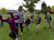 Cheri Larsen, a registered horticulture therapist, teaches youngsters at Hough Elementary School how to make leaf pressings. Students Jennifer Nguyen, 6, from left, Jaime Madsen, 5, Felix North, 6, and Clark Cozens, 6, help collect leaves for the recess activity, which is offered every week under Larsen’s instruction.