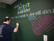 Matthew Kleen of Birkenfeld, Ore., writes a gratitude statement on the wall at the Pain Relief Partners pain clinic in Vancouver. Kleen hopes to get off pain medication so he makes the 90-minute drive to Pain Relief Partners to try new therapies to help with his pain.